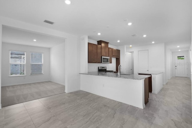 8632 Snowfall St, Sarasota, FL 34241 - kitchen with stainless steel appliances, recessed lighting, light stone counters, and a peninsula