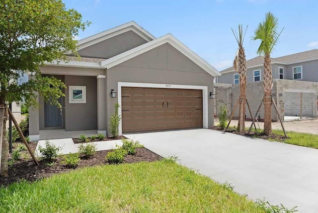 8632 Snowfall St, Sarasota, FL 34241 - view of front of property with an attached garage, stucco siding, and concrete driveway