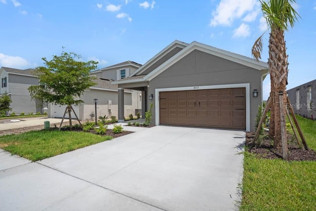 8632 Snowfall St, Sarasota, FL 34241 - view of front of house featuring a garage, driveway, and stucco siding