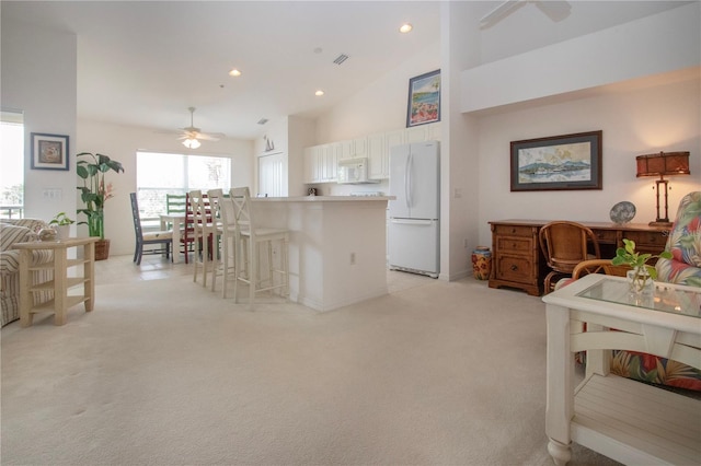 5330 Hyland Hills Ave Unit 2324, Sarasota, FL 34241 - kitchen with white appliances, a ceiling fan, a breakfast bar, high vaulted ceiling, and light colored carpet