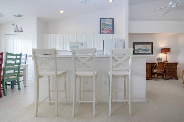 5330 Hyland Hills Ave Unit 2324, Sarasota, FL 34241 - kitchen with white appliances, vaulted ceiling, a breakfast bar area, light carpet, and recessed lighting
