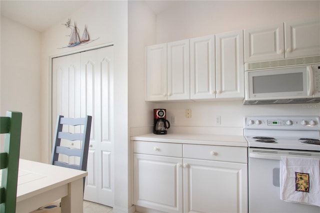 5330 Hyland Hills Ave Unit 2324, Sarasota, FL 34241 - kitchen featuring white appliances, white cabinets, light countertops, and light tile patterned floors