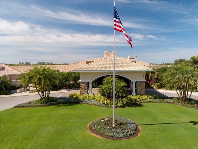 5330 Hyland Hills Ave Unit 2324, Sarasota, FL 34241 - view of front facade featuring a chimney, a tile roof, a front yard, stucco siding, and stone siding