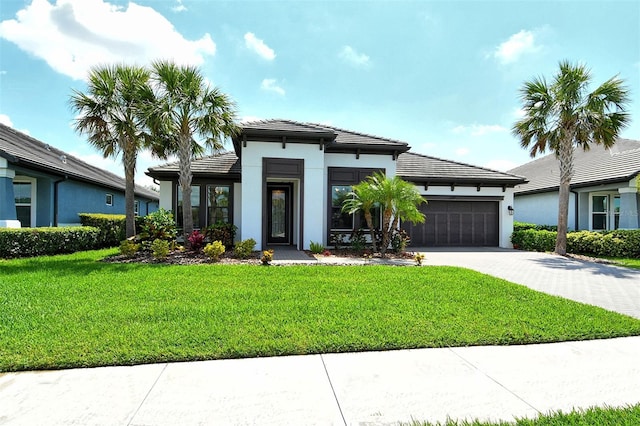 1919 Woodleaf Hammock Ct, Bradenton, FL 34211 - prairie-style home featuring a garage, driveway, a tile roof, a front lawn, and stucco siding