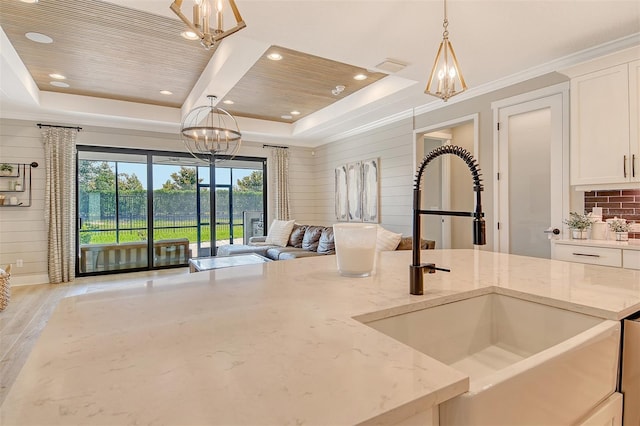 1919 Woodleaf Hammock Ct, Bradenton, FL 34211 - kitchen featuring a sink, a chandelier, open floor plan, a raised ceiling, and white cabinetry