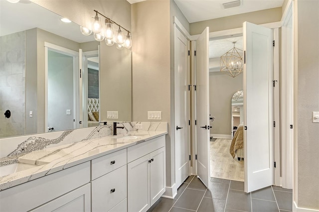 1919 Woodleaf Hammock Ct, Bradenton, FL 34211 - full bath with connected bathroom, double vanity, tile patterned floors, a chandelier, and baseboards