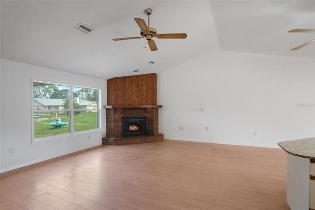 5639 Blount Ave, Sarasota, FL 34231 - unfurnished living room with ceiling fan, vaulted ceiling, light wood-type flooring, a fireplace, and baseboards