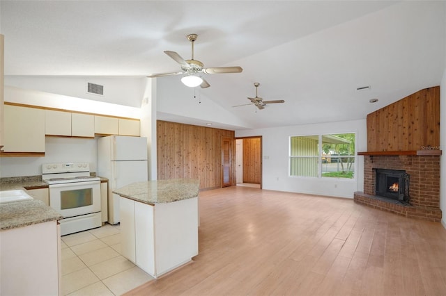 5639 Blount Ave, Sarasota, FL 34231 - kitchen with white appliances, wooden walls, ceiling fan, open floor plan, and a kitchen island