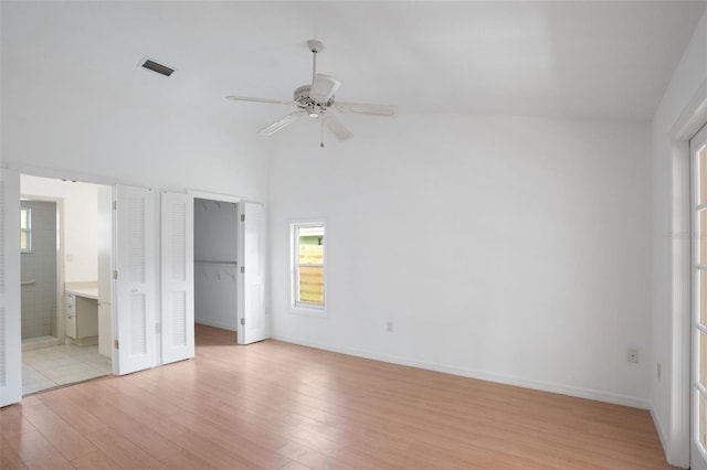 5639 Blount Ave, Sarasota, FL 34231 - unfurnished bedroom featuring light wood finished floors, ensuite bathroom, a spacious closet, high vaulted ceiling, and ceiling fan