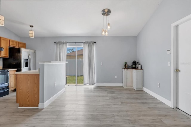 3429 97th Ln E, Palmetto, FL 34221 - kitchen with stainless steel fridge with ice dispenser, light wood-type flooring, decorative light fixtures, light countertops, and baseboards