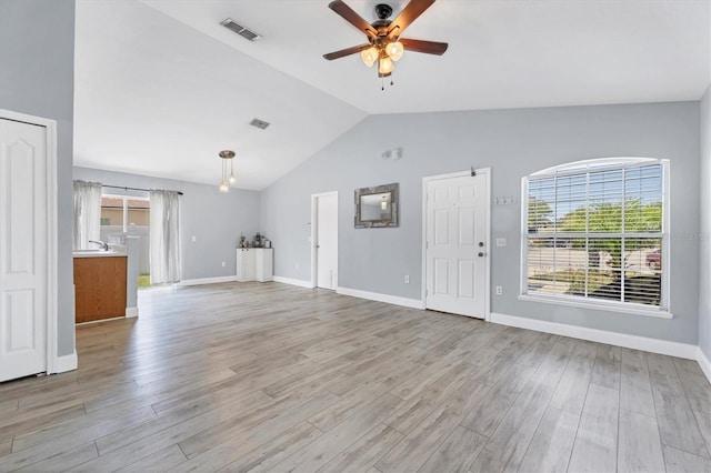 3429 97th Ln E, Palmetto, FL 34221 - unfurnished living room with a ceiling fan, vaulted ceiling, light wood-style floors, and baseboards