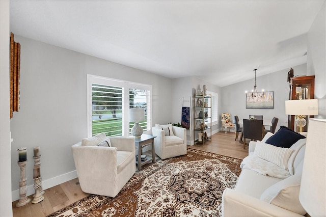 4844 14th Ave E, Bradenton, FL 34208 - living room featuring a chandelier, wood finished floors, baseboards, and vaulted ceiling