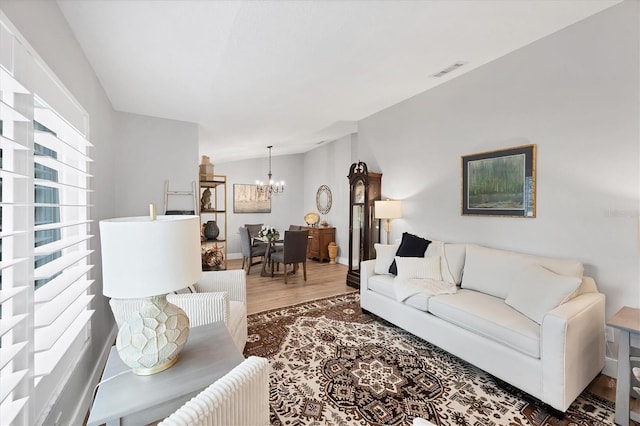 4844 14th Ave E, Bradenton, FL 34208 - living room featuring a chandelier, wood finished floors, vaulted ceiling, and baseboards