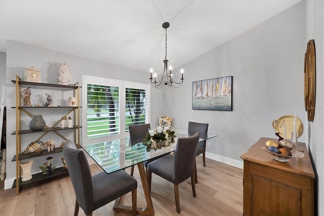 4844 14th Ave E, Bradenton, FL 34208 - dining area featuring a chandelier, light wood-style flooring, lofted ceiling, and baseboards