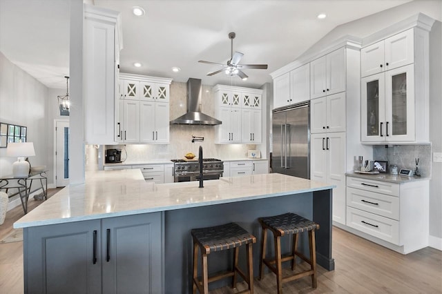 4844 14th Ave E, Bradenton, FL 34208 - kitchen with wall chimney range hood, premium appliances, a peninsula, ceiling fan, and backsplash