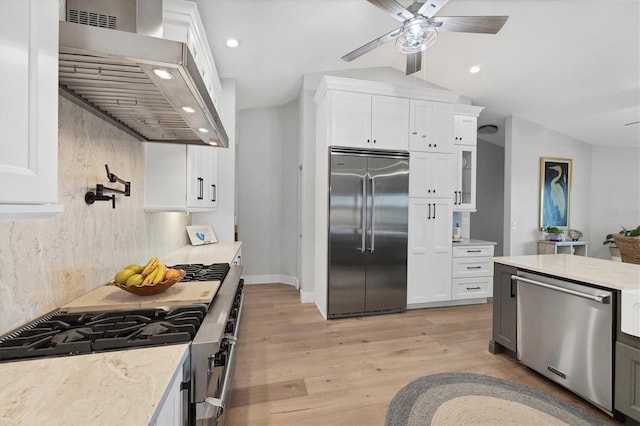 4844 14th Ave E, Bradenton, FL 34208 - kitchen featuring stainless steel appliances, wall chimney exhaust hood, light wood-style flooring, white cabinets, and ceiling fan