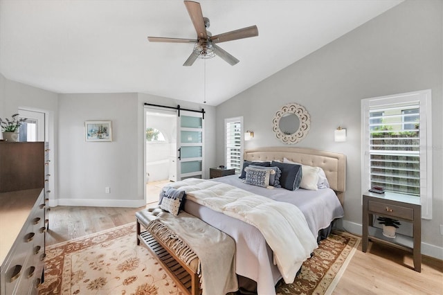 4844 14th Ave E, Bradenton, FL 34208 - bedroom featuring a barn door, light wood-style floors, baseboards, vaulted ceiling, and ensuite bath