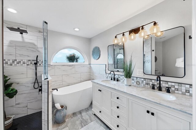 4844 14th Ave E, Bradenton, FL 34208 - bathroom featuring marble finish floors, double vanity, a freestanding tub, a marble finish shower, and tile walls