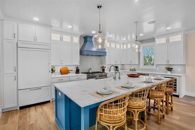 135 Avenida Veneccia, Sarasota, FL 34242 - kitchen with premium range hood, beverage cooler, high end appliances, light wood-type flooring, and recessed lighting