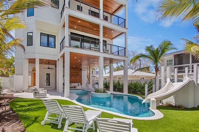 135 Avenida Veneccia, Sarasota, FL 34242 - rear view of house featuring a balcony, a ceiling fan, a patio, and a pool with connected hot tub