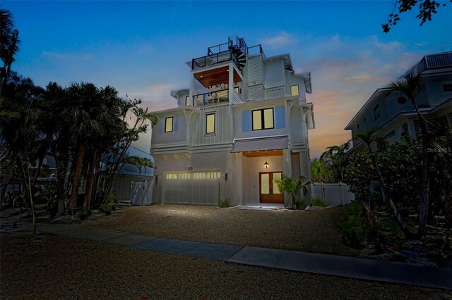 135 Avenida Veneccia, Sarasota, FL 34242 - coastal inspired home with a balcony, stucco siding, dirt driveway, an attached garage, and french doors