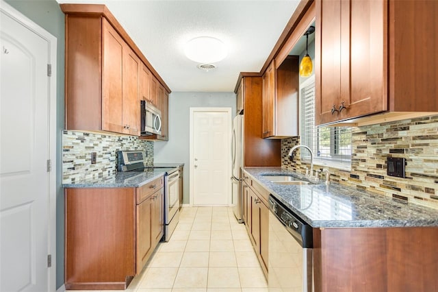 4375 Tortoise Rd, Venice, FL 34293 - kitchen with appliances with stainless steel finishes, a sink, decorative backsplash, dark stone counters, and light tile patterned flooring