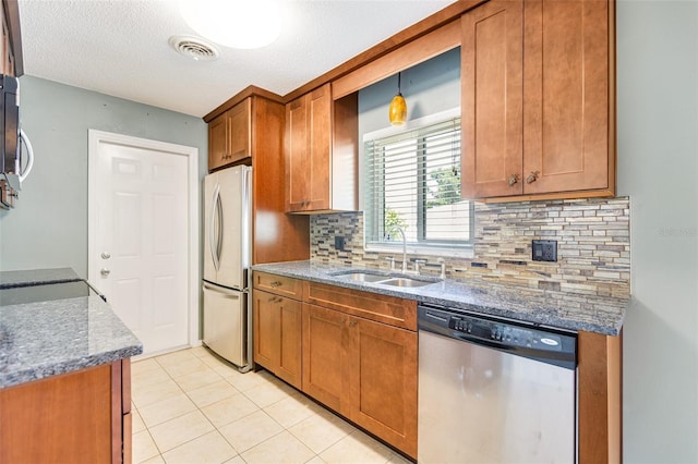4375 Tortoise Rd, Venice, FL 34293 - kitchen featuring appliances with stainless steel finishes, a sink, brown cabinets, backsplash, and a textured ceiling