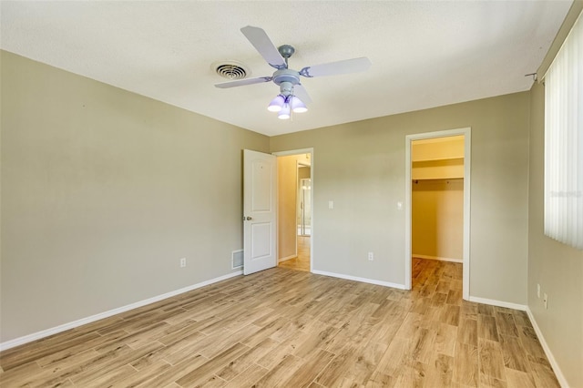4375 Tortoise Rd, Venice, FL 34293 - unfurnished bedroom with light wood-type flooring, baseboards, a walk in closet, and a ceiling fan