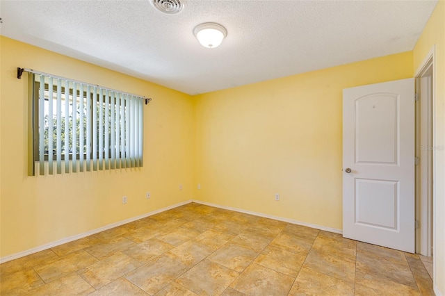 4375 Tortoise Rd, Venice, FL 34293 - empty room featuring a textured ceiling, baseboards, and light stone finish flooring