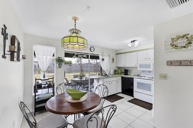 4535 Maceachen Blvd, Sarasota, FL 34233 - kitchen with white appliances, light countertops, light tile patterned flooring, white cabinetry, and a sink