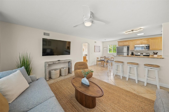 308 Canal Rd, Sarasota, FL 34242 - living room featuring light tile patterned floors, a ceiling fan, baseboards, and arched walkways