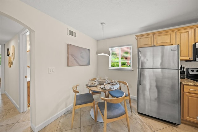 308 Canal Rd, Sarasota, FL 34242 - kitchen with appliances with stainless steel finishes, arched walkways, light tile patterned floors, and baseboards