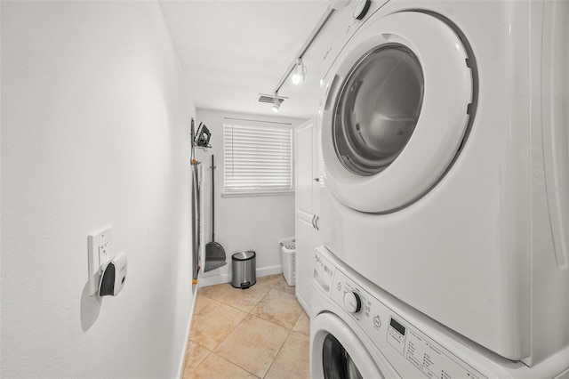 308 Canal Rd, Sarasota, FL 34242 - laundry room with stacked washing machine and dryer, light tile patterned flooring, track lighting, and baseboards