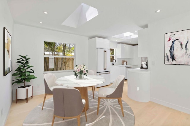 2410 Floyd St, Sarasota, FL 34239 - dining room featuring a skylight, light wood-style flooring, and recessed lighting