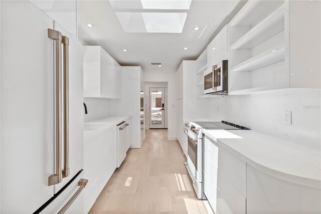 2410 Floyd St, Sarasota, FL 34239 - kitchen with modern cabinets, white appliances, open shelves, white cabinetry, and light wood finished floors