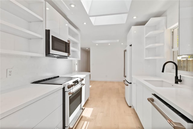 2410 Floyd St, Sarasota, FL 34239 - kitchen with open shelves, white appliances, modern cabinets, white cabinetry, and light countertops