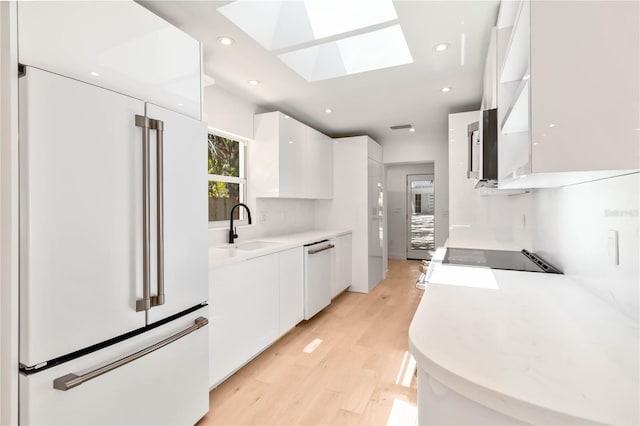 2410 Floyd St, Sarasota, FL 34239 - kitchen with white built in refrigerator, modern cabinets, dishwasher, white cabinetry, and light wood-type flooring