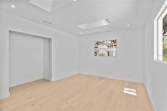 2410 Floyd St, Sarasota, FL 34239 - unfurnished room featuring a skylight, healthy amount of natural light, wood finished floors, and recessed lighting