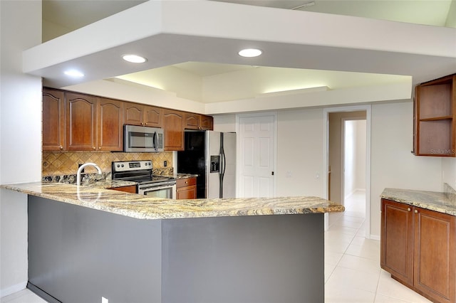5905 32nd St E, Ellenton, FL 34222 - kitchen with appliances with stainless steel finishes, a peninsula, tasteful backsplash, light stone counters, and recessed lighting