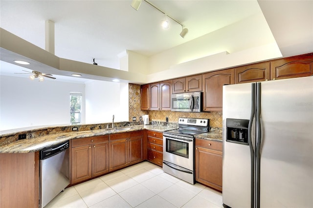 5905 32nd St E, Ellenton, FL 34222 - kitchen with appliances with stainless steel finishes, stone counters, a peninsula, backsplash, and light tile patterned floors