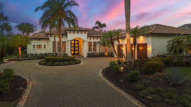 8312 Catamaran Cir, Lakewood Ranch, FL 34202 - mediterranean / spanish home with stucco siding, curved driveway, french doors, and a tile roof