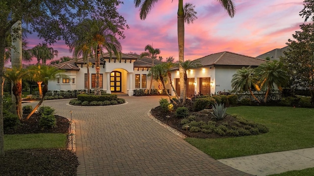 8312 Catamaran Cir, Lakewood Ranch, FL 34202 - mediterranean / spanish-style house with french doors, stucco siding, curved driveway, and a lawn