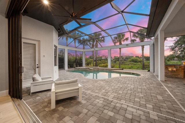 8312 Catamaran Cir, Lakewood Ranch, FL 34202 - pool at dusk with a patio, exterior kitchen, a pool with connected hot tub, and glass enclosure