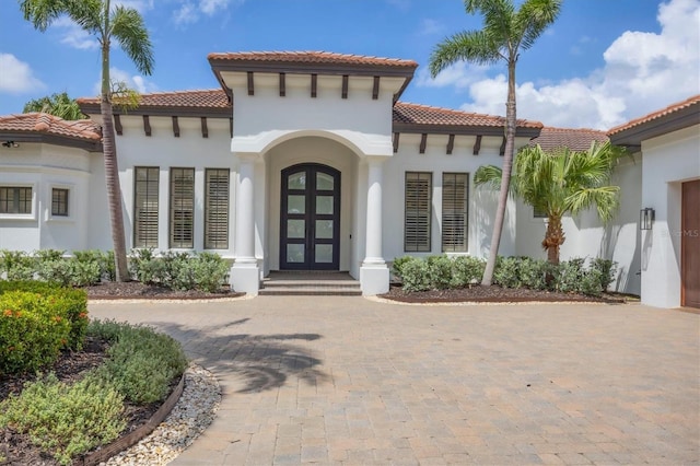 8312 Catamaran Cir, Lakewood Ranch, FL 34202 - doorway to property with a tiled roof, stucco siding, french doors, and curved driveway