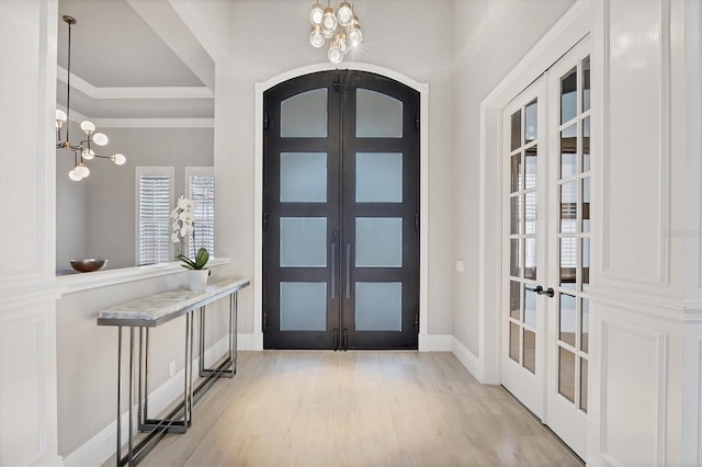 8312 Catamaran Cir, Lakewood Ranch, FL 34202 - entryway featuring french doors, a chandelier, light wood-type flooring, and crown molding