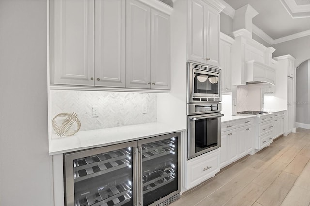 8312 Catamaran Cir, Lakewood Ranch, FL 34202 - kitchen featuring stainless steel appliances, light countertops, tasteful backsplash, light wood-type flooring, and white cabinets