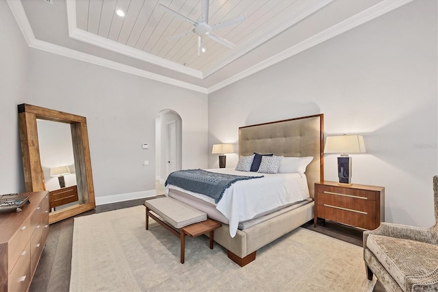 8312 Catamaran Cir, Lakewood Ranch, FL 34202 - bedroom featuring arched walkways, a tray ceiling, wood finished floors, baseboards, and ornamental molding
