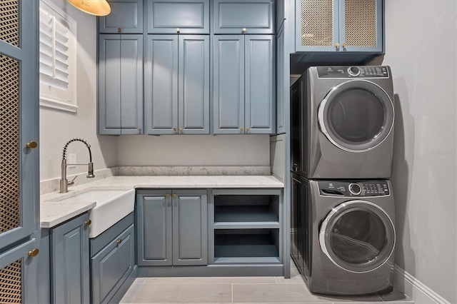 8312 Catamaran Cir, Lakewood Ranch, FL 34202 - laundry area featuring cabinet space, stacked washing machine and dryer, and light tile patterned floors