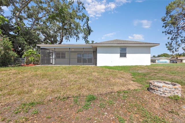 6572 Mauna Loa Blvd, Sarasota, FL 34241 - rear view of property with a sunroom, a fire pit, stucco siding, and a lawn