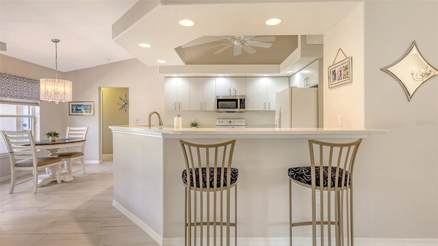 5698 Country Walk Ln, Sarasota, FL 34233 - kitchen featuring freestanding refrigerator, stainless steel microwave, baseboards, a ceiling fan, and a peninsula